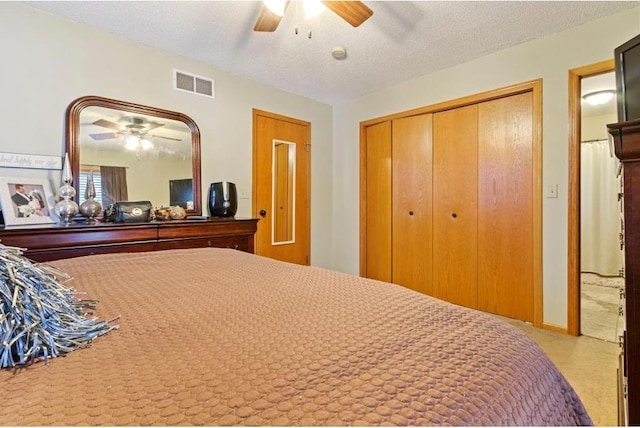 carpeted bedroom with a textured ceiling, a closet, and ceiling fan