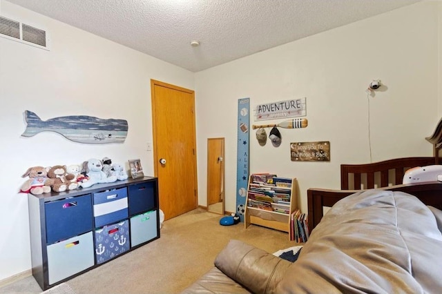 bedroom with light colored carpet and a textured ceiling