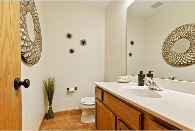 bathroom with vanity, wood-type flooring, and toilet