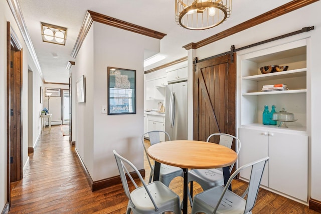 dining room featuring a barn door, dark wood-type flooring, and ornamental molding