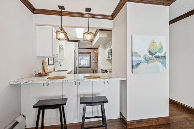 kitchen with sink, hanging light fixtures, baseboard heating, kitchen peninsula, and white cabinets