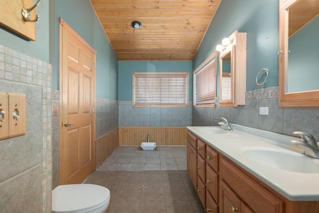 bathroom featuring toilet, wooden ceiling, a sink, and wainscoting