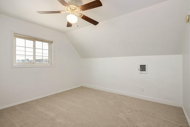 additional living space featuring light colored carpet, vaulted ceiling, baseboards, and ceiling fan