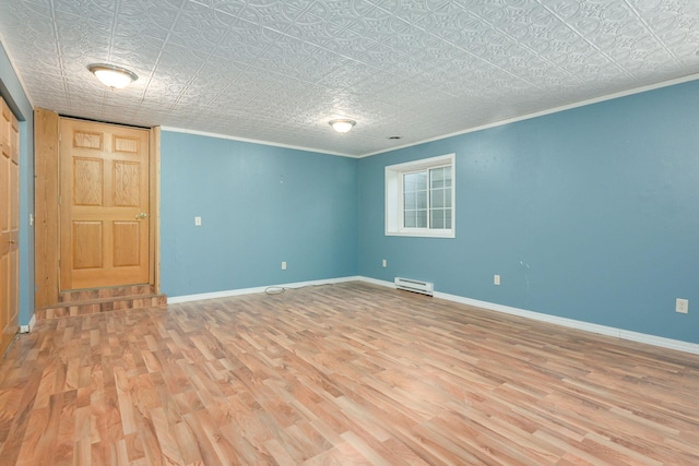 empty room with a baseboard radiator, baseboards, and wood finished floors