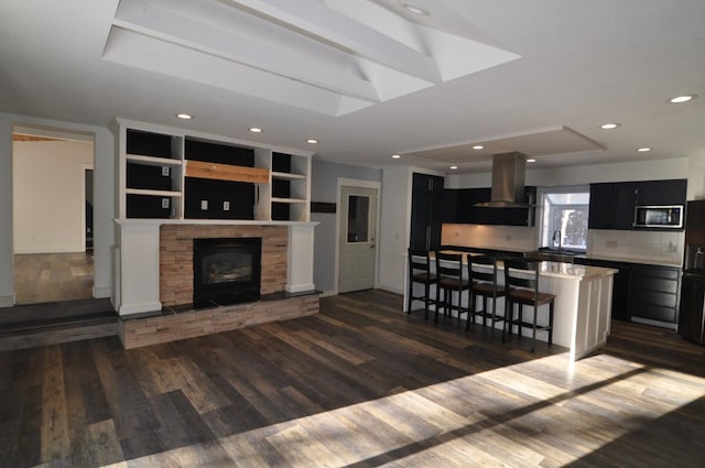 living room with a fireplace, built in features, dark hardwood / wood-style flooring, and sink