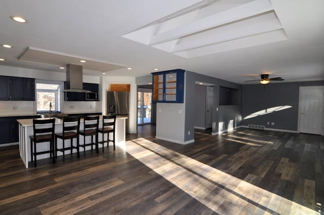 living room featuring sink, dark hardwood / wood-style flooring, ceiling fan, and a tray ceiling