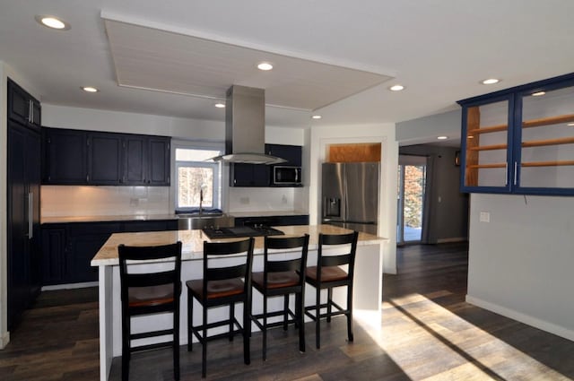 kitchen with a center island, stainless steel appliances, island exhaust hood, dark hardwood / wood-style flooring, and a kitchen breakfast bar