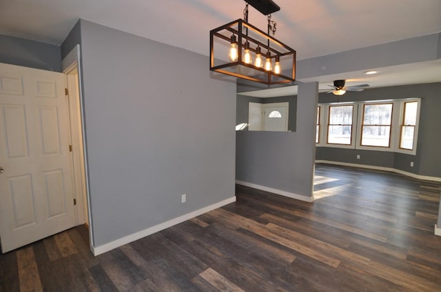 unfurnished dining area featuring dark wood-type flooring and ceiling fan