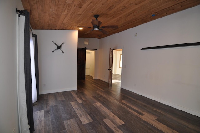 empty room featuring dark hardwood / wood-style flooring, wooden ceiling, ceiling fan, and a barn door