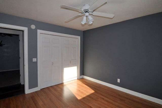 unfurnished bedroom featuring wood-type flooring, ceiling fan, and a closet