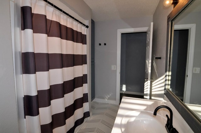 bathroom featuring sink and a textured ceiling