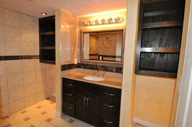 bathroom with tile walls, tile patterned flooring, and vanity