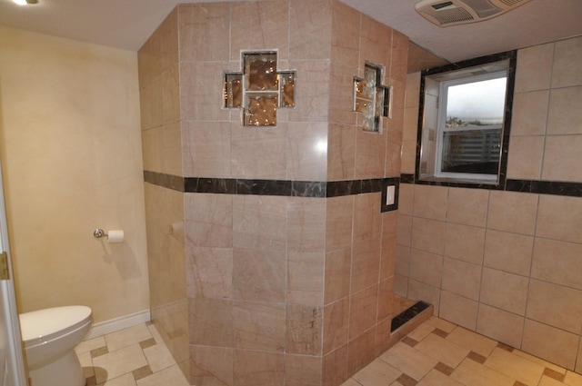 bathroom with toilet and tiled shower