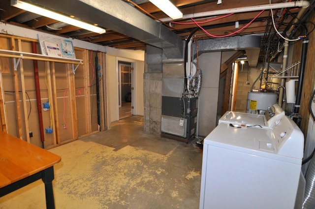 basement featuring water heater, heating unit, and independent washer and dryer