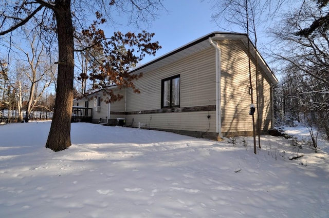 snow covered property with a wooden deck