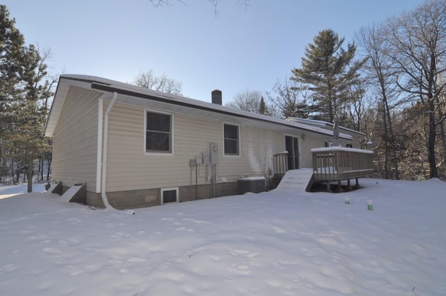 snow covered house featuring a wooden deck and central air condition unit