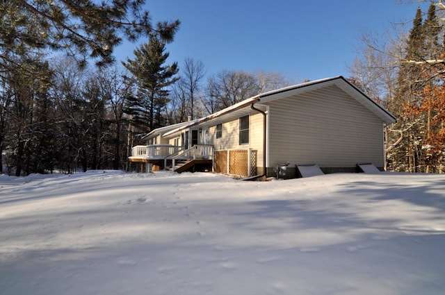 snow covered property with a wooden deck