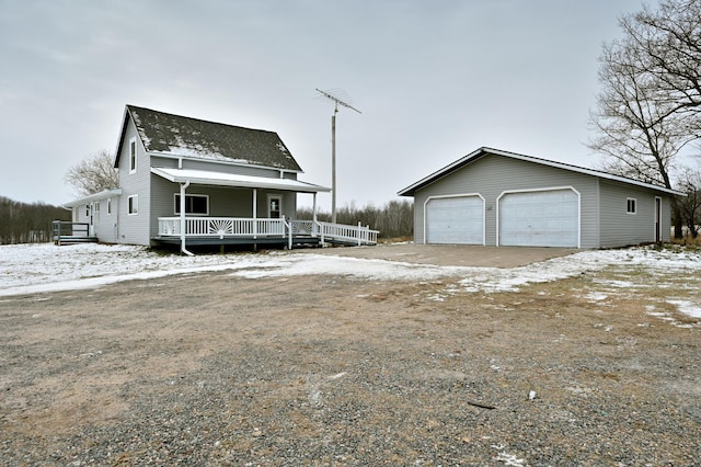 view of front of property featuring a porch, a garage, and an outbuilding