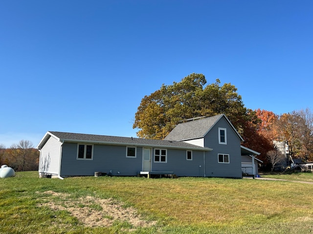 rear view of house featuring a yard