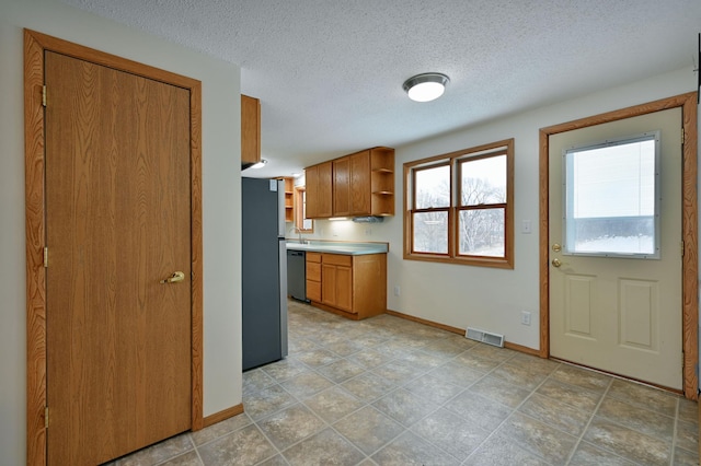 kitchen with sink, a textured ceiling, and appliances with stainless steel finishes