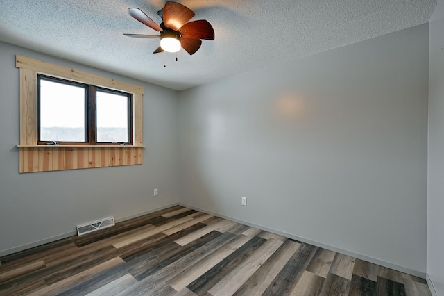 empty room with ceiling fan, a textured ceiling, and dark wood-type flooring