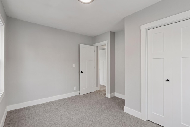 unfurnished bedroom featuring a closet and light carpet