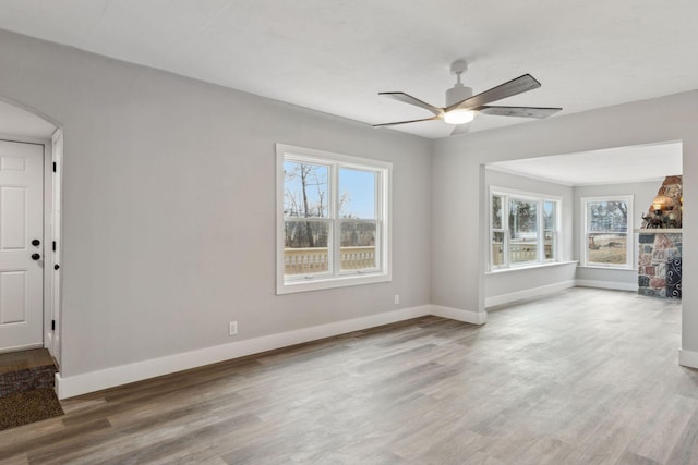 unfurnished living room with hardwood / wood-style floors, plenty of natural light, and ceiling fan