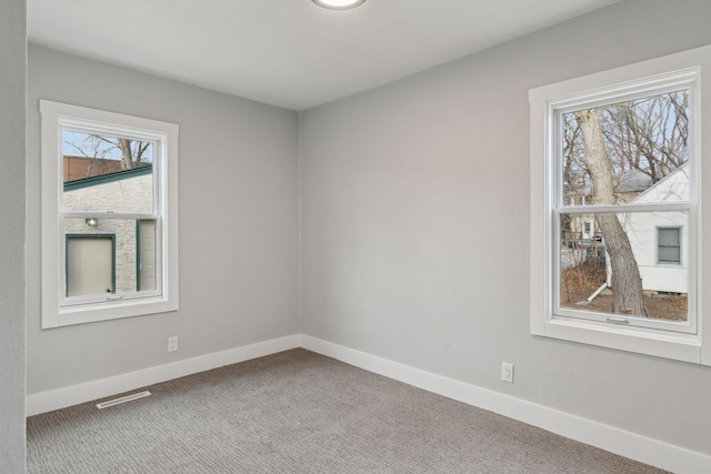 carpeted empty room with plenty of natural light