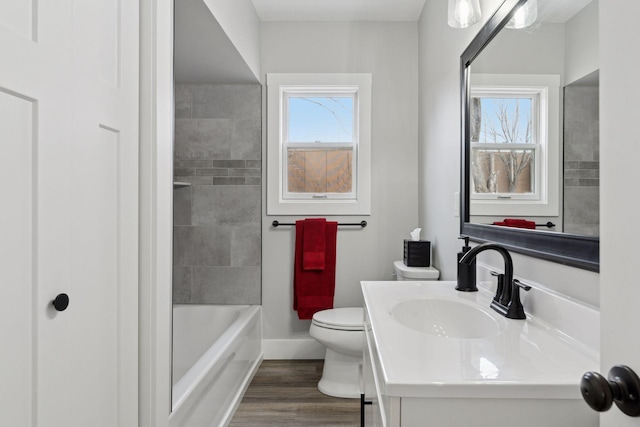 full bathroom with wood-type flooring, toilet, vanity, and tiled shower / bath combo