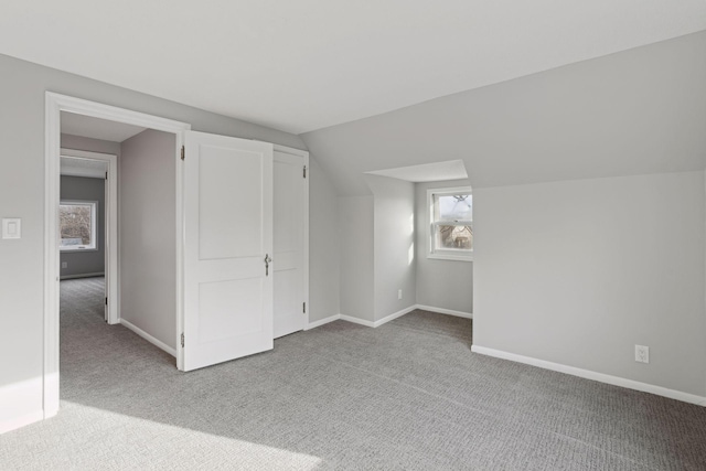 additional living space featuring light carpet and lofted ceiling