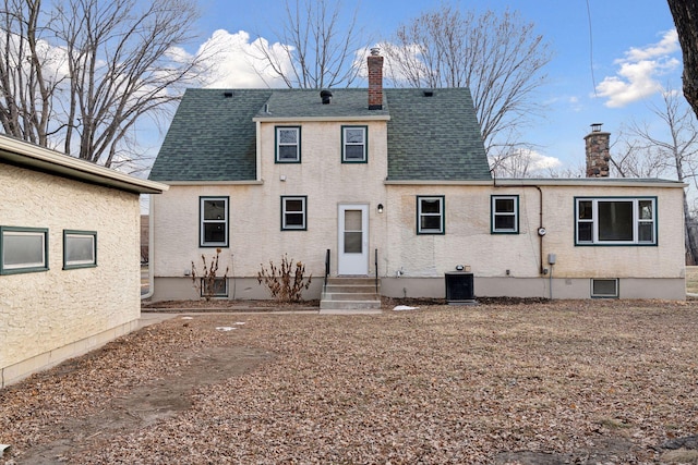 rear view of property with central AC