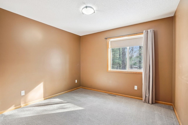 carpeted spare room featuring a textured ceiling