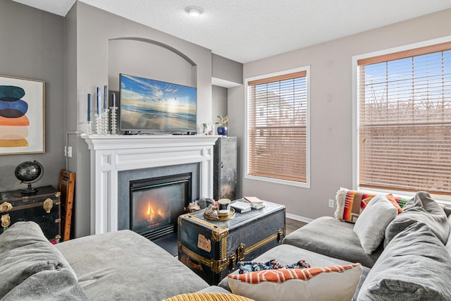 living room featuring a textured ceiling and a fireplace