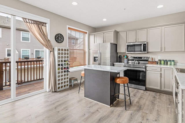 kitchen featuring a breakfast bar area, stainless steel appliances, plenty of natural light, and a center island