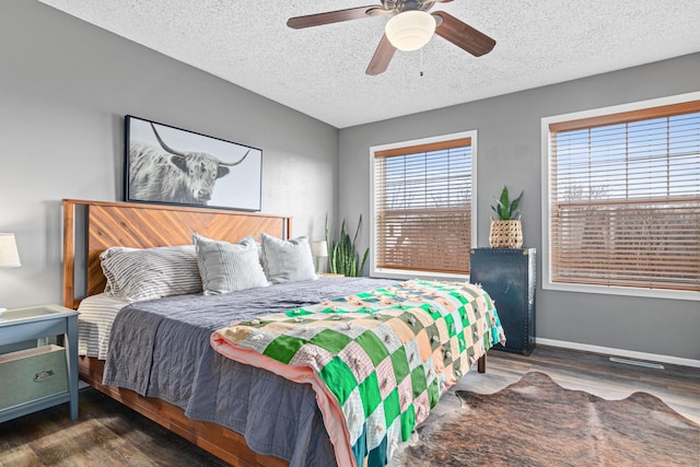 bedroom featuring ceiling fan, dark hardwood / wood-style floors, and a textured ceiling