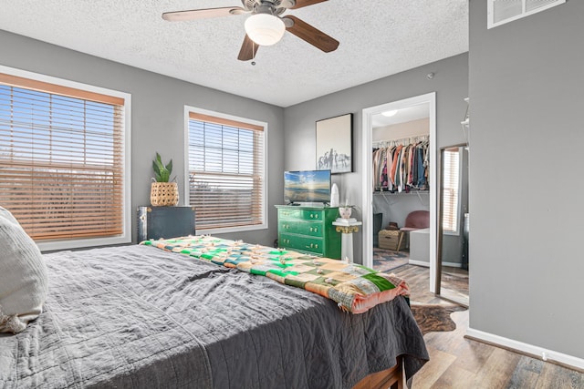 bedroom featuring ceiling fan, hardwood / wood-style floors, a closet, and a textured ceiling