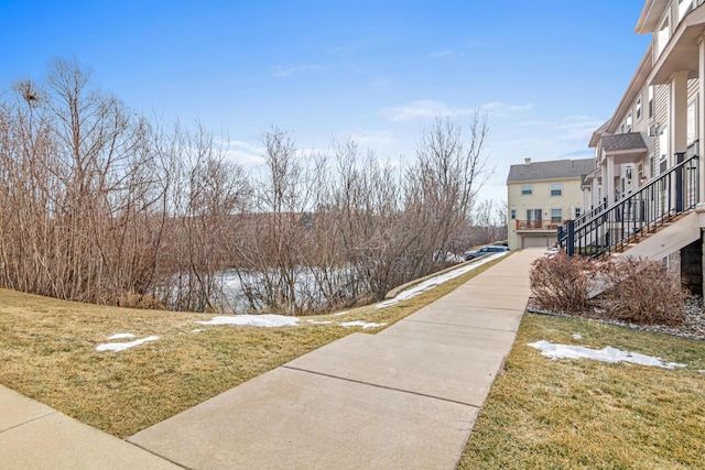 view of property's community with a water view and a lawn