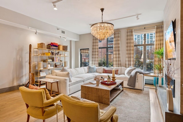 living room with a notable chandelier and light hardwood / wood-style flooring