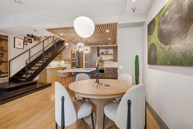 dining room with indoor wet bar and light hardwood / wood-style floors