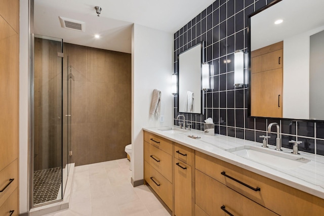 bathroom with toilet, backsplash, tile patterned floors, walk in shower, and vanity