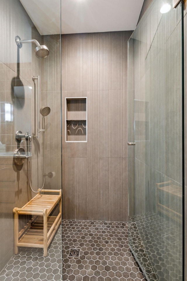 bathroom with tile patterned flooring and a tile shower