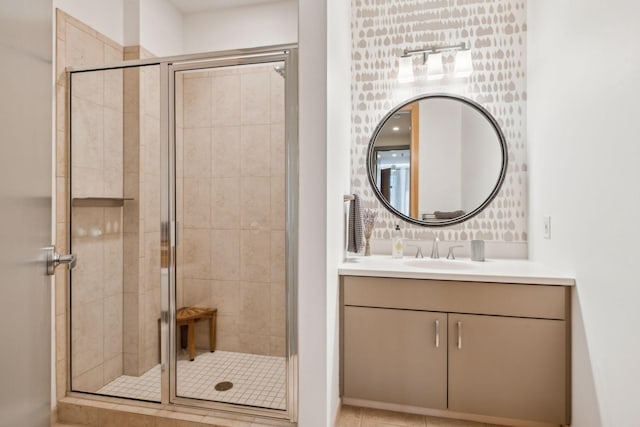 bathroom featuring tile patterned floors, an enclosed shower, and vanity