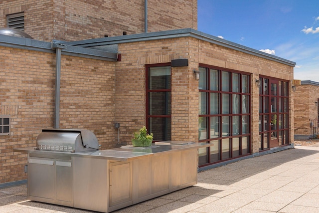 view of patio / terrace with exterior kitchen and a grill