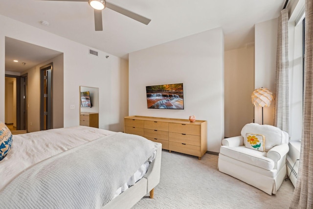 bedroom featuring visible vents, a ceiling fan, and light colored carpet