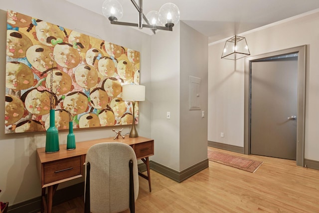 home office with baseboards, wood finished floors, and a notable chandelier