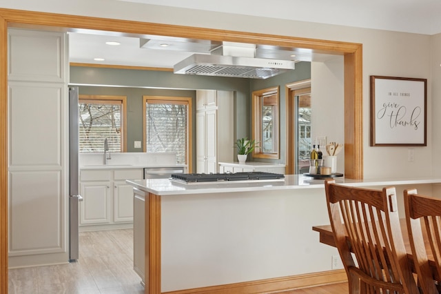 kitchen with light countertops, recessed lighting, appliances with stainless steel finishes, white cabinets, and a sink