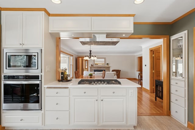 kitchen featuring a peninsula, white cabinets, light countertops, and appliances with stainless steel finishes