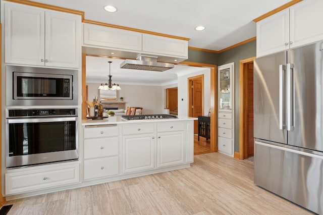 kitchen featuring appliances with stainless steel finishes, a peninsula, ornamental molding, and white cabinetry