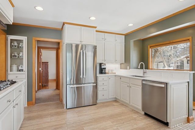 kitchen with white cabinetry, light countertops, appliances with stainless steel finishes, and a sink