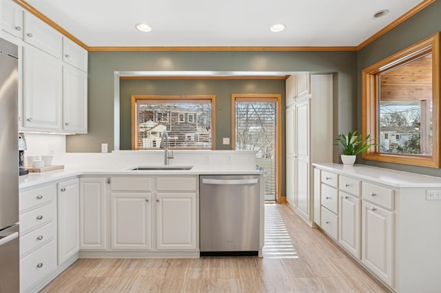 kitchen featuring a sink, recessed lighting, appliances with stainless steel finishes, white cabinets, and light countertops